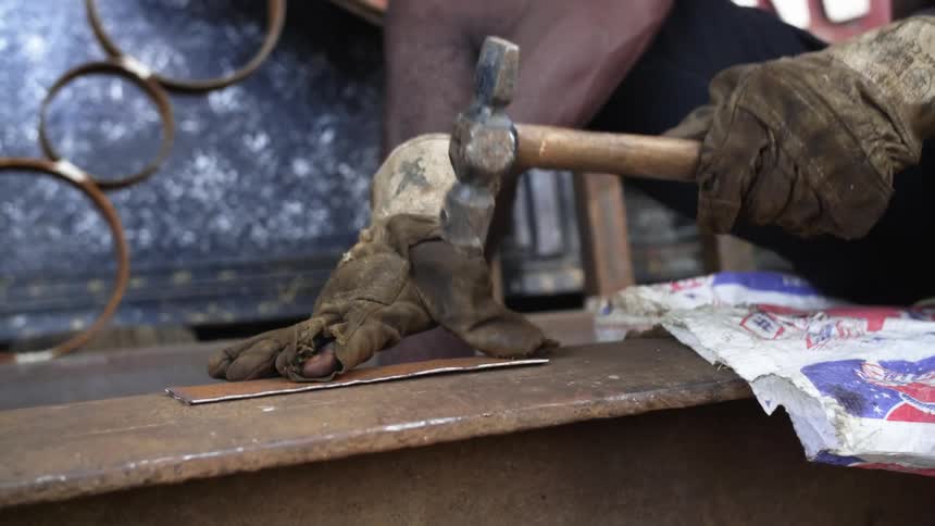 A person with gloves using a hammer