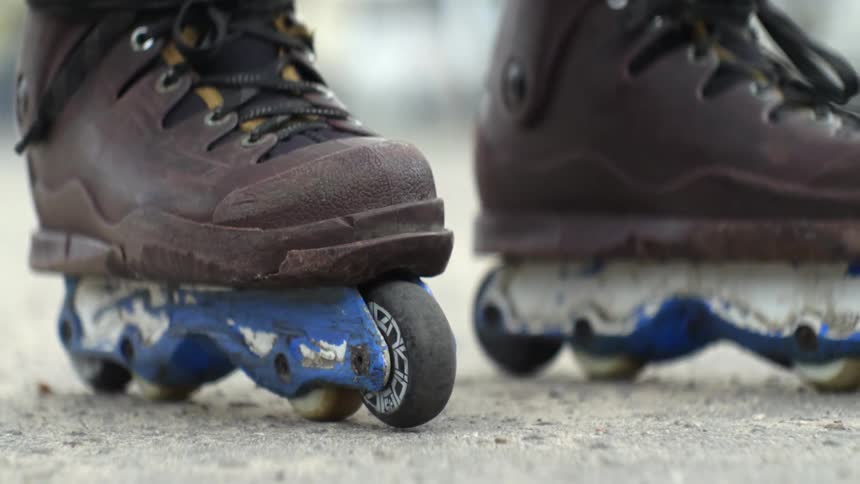 Person wearing brown inline skates pushes off