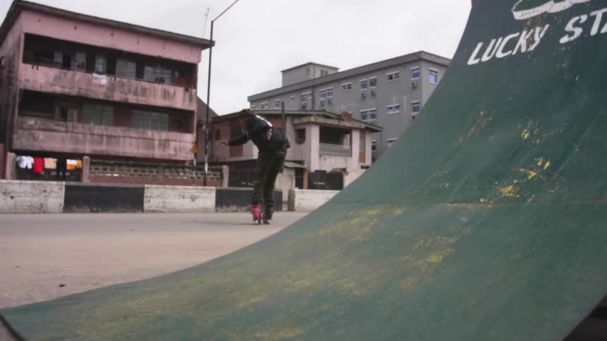 A man jumping off a ramp wearing roller blades