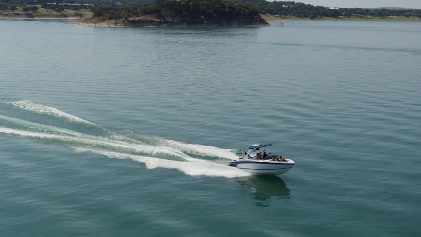 A boat on a body of water with land the sky and clouds in the background