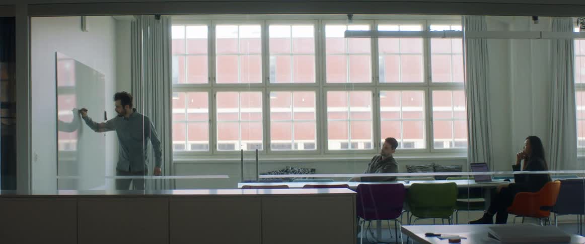 Man writting on a whiteboard in an office meeting in the conference room