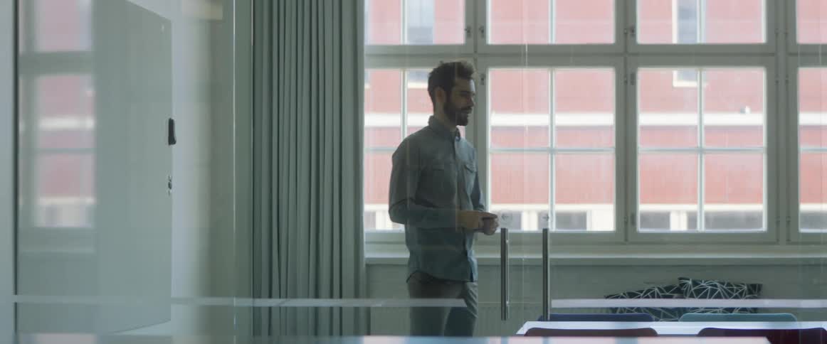 A teacher writes on a white board and talks as a student sits and listens