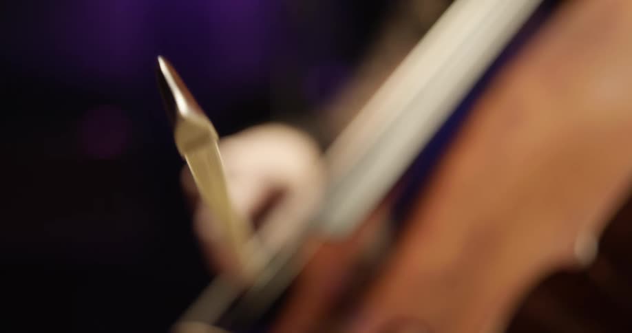 Woman uses a bow to play cello