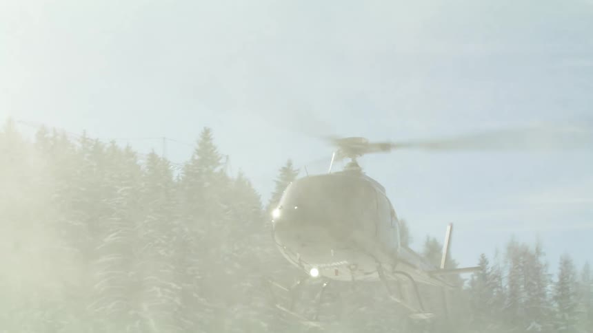 A helicopter taking off from a snowy area
