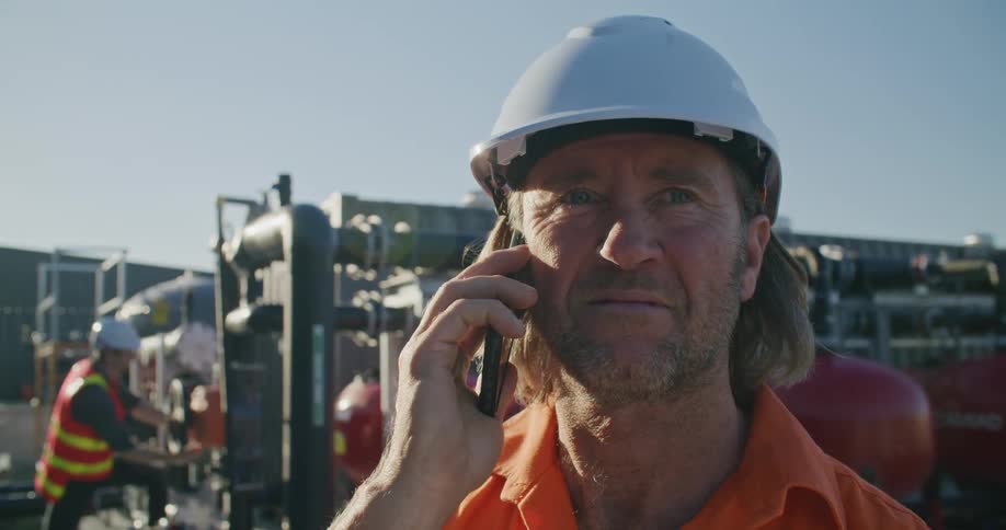 A construction worker talking on a cell phone outdoors