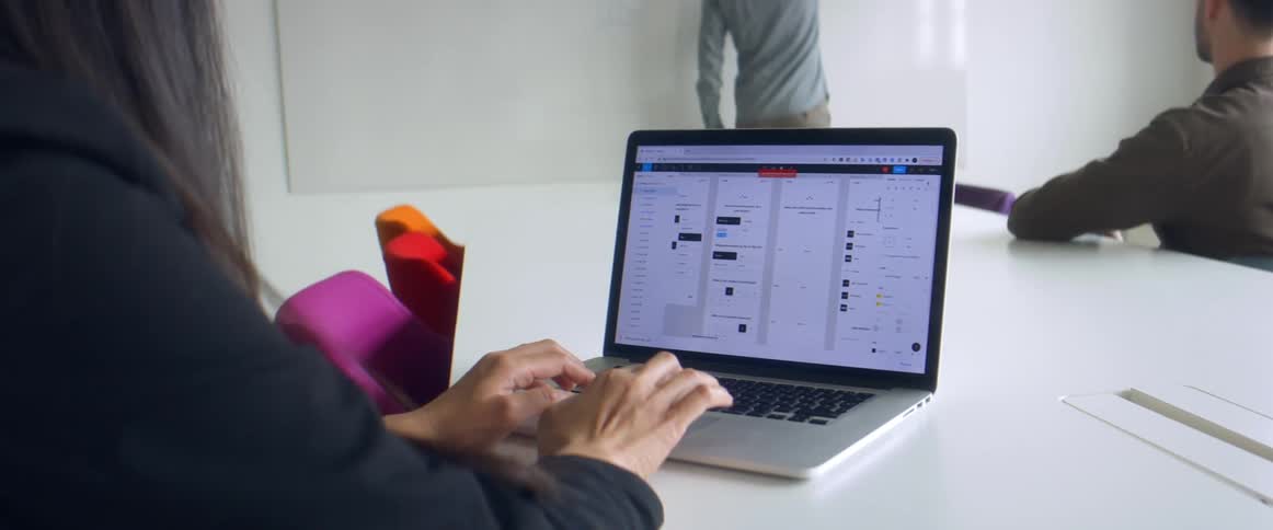Woman typing on a laptop over the desk in the office at a meeting