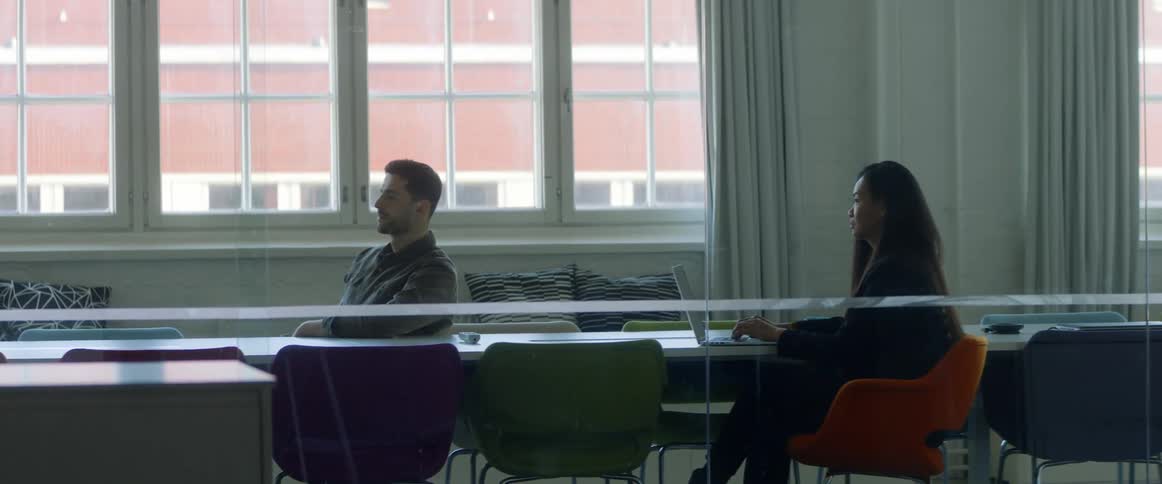 People sitting at the desk in the office at a meeting in a conference room