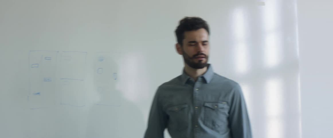 Man writting on a whiteboard in an office meeting in the conference room