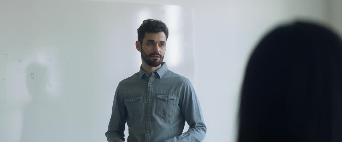 A man working in an office in front of a white board
