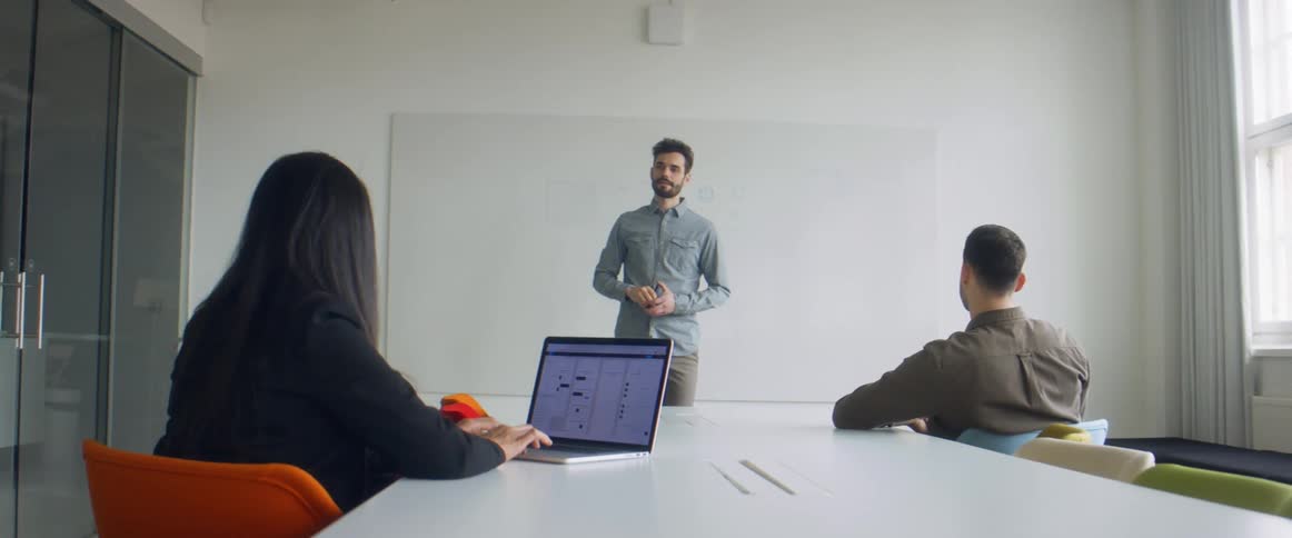 Man writting on a whiteboard in an office meeting in the conference room