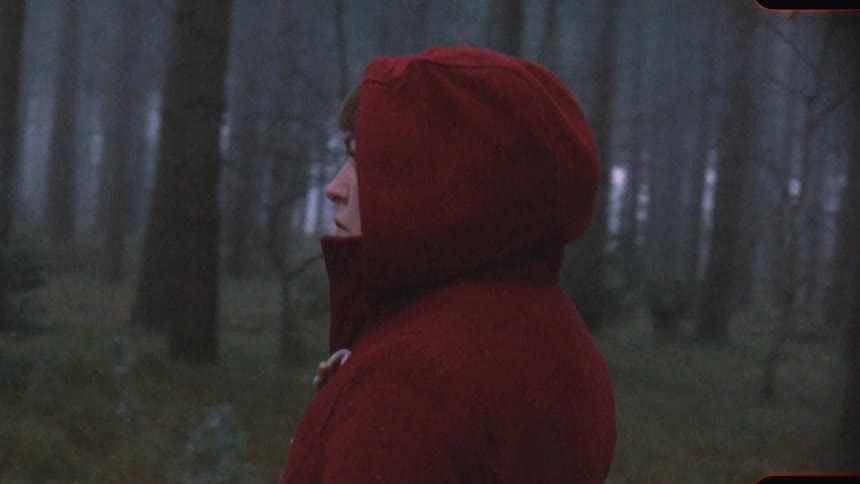 A woman walking through a forest on analog Film