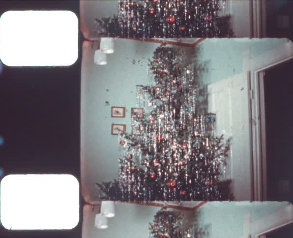 A christmas tree covered in decorations in a house during the day