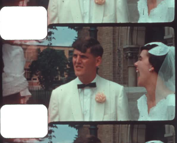 A bride and groom smile laugh and talk with others outside the church