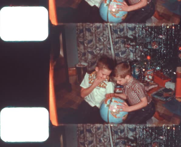 Brothers opening chirstmas presents at home caught on vintage film