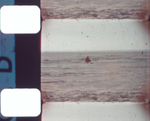 A person standing in an open field being filmed on vintage film
