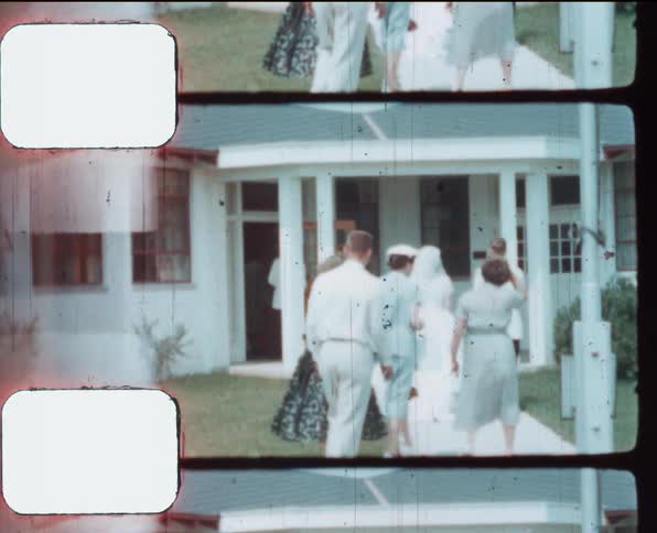Groom and bride entering a building after the ceremony caught on vintage film