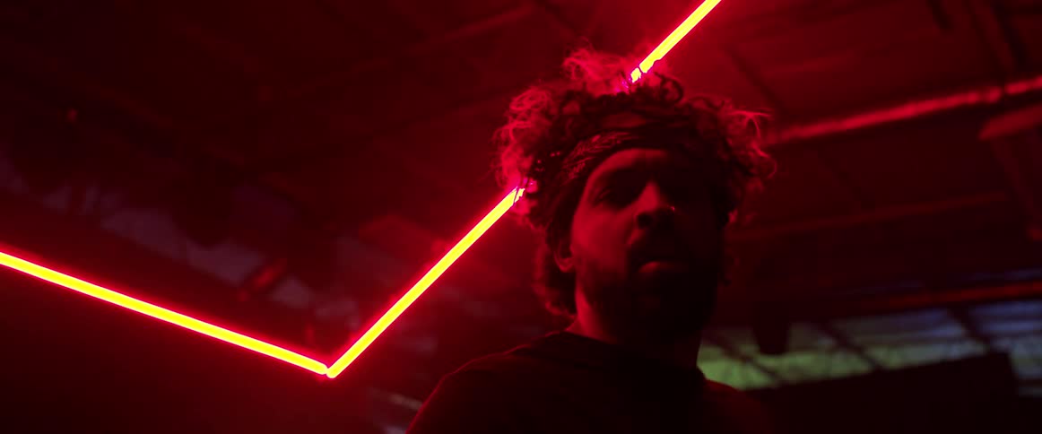 A man with a head bandanna in a room with lights and the ceiling in the background
