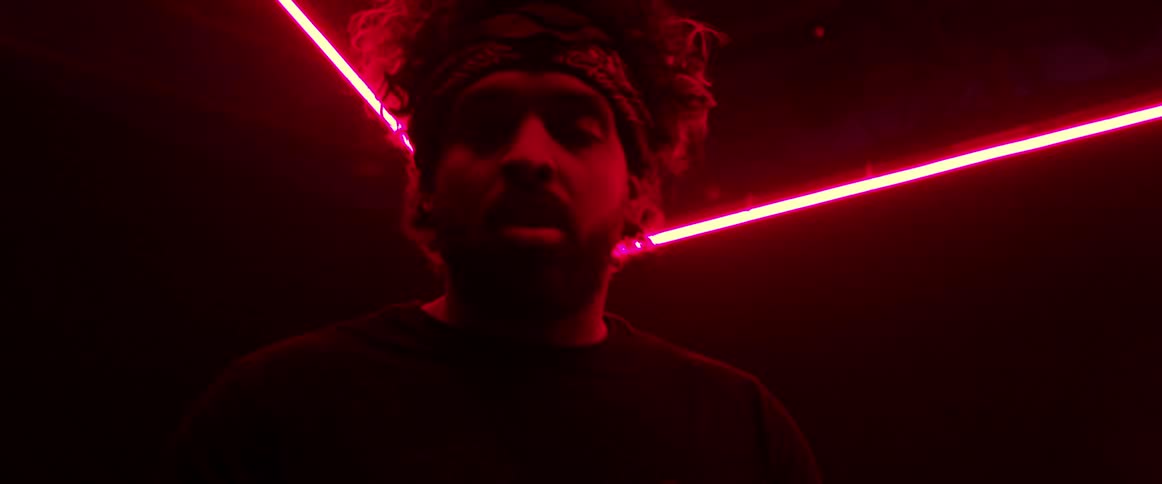 A man sings on a stage with neon lights