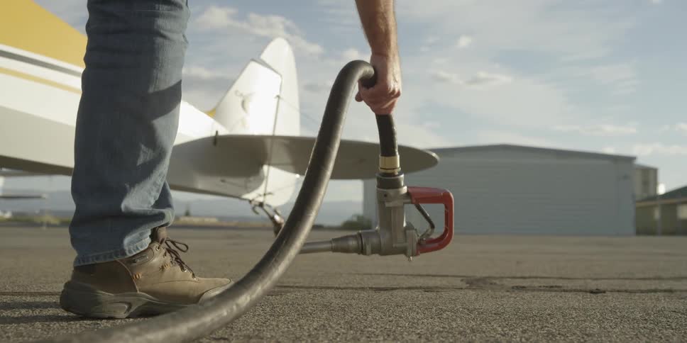 A person picks up a gas pump from the ground