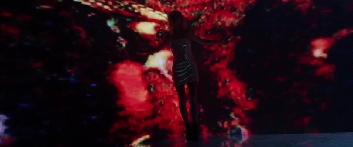 A woman standing on a stage with a screen behind her