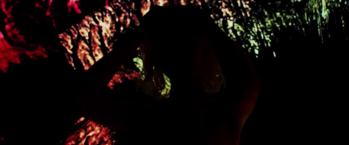 A model stands in front of bright lights and runs her hands through her hair
