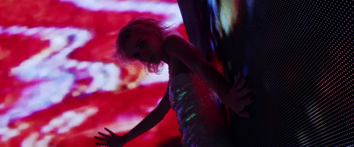 A view of a woman standing near led screens