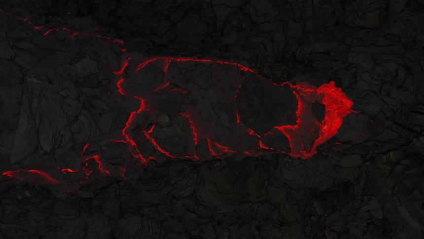 Hot red lava slowly breaking the black ground surface