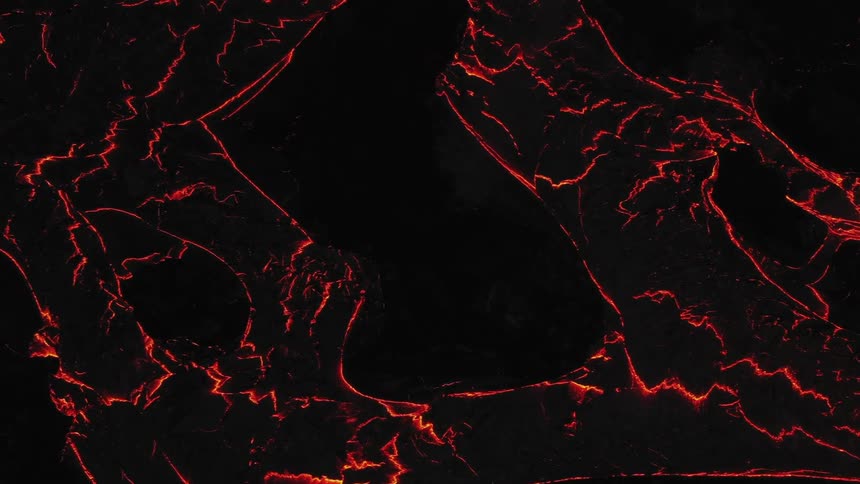 A large quantity of glowing hot lava flows down the side of a volcano