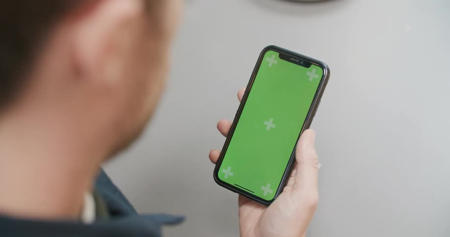 A man staring at a smartphone in his palm