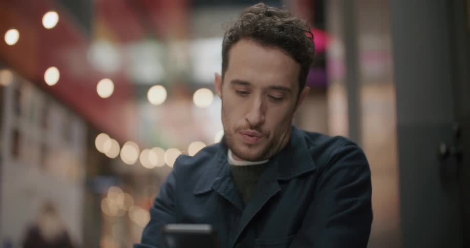 A man is sitting in a restaurant indoors