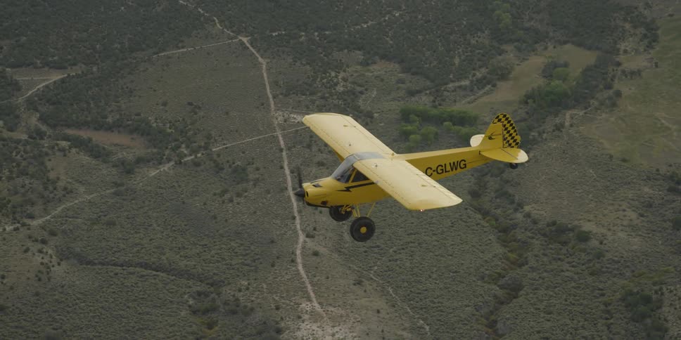 A yellow plane is flying high in the sky