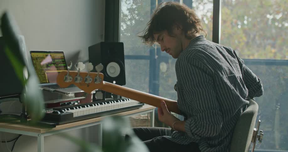 A man at home plays the guitar