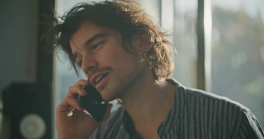 A man talking on a cell phone in a house