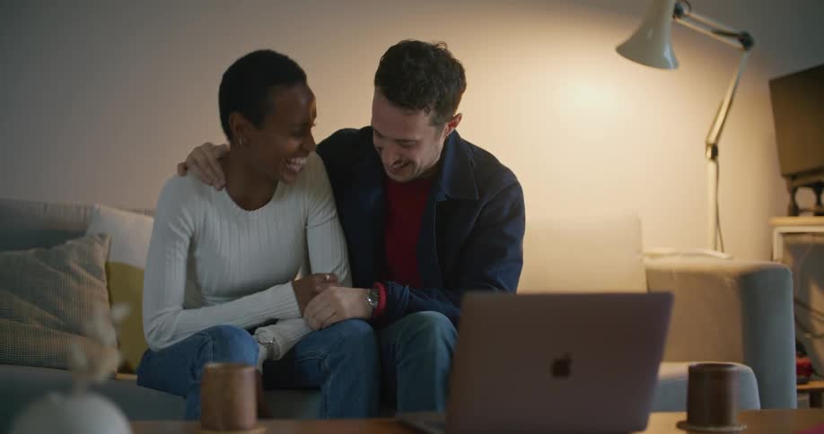 A man and woman talking on a laptop