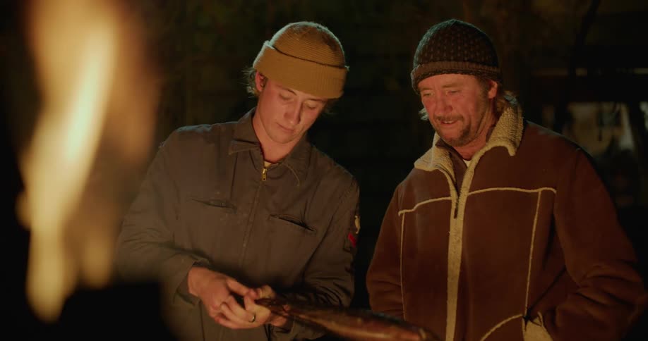 Father and son preparing a fish to cook