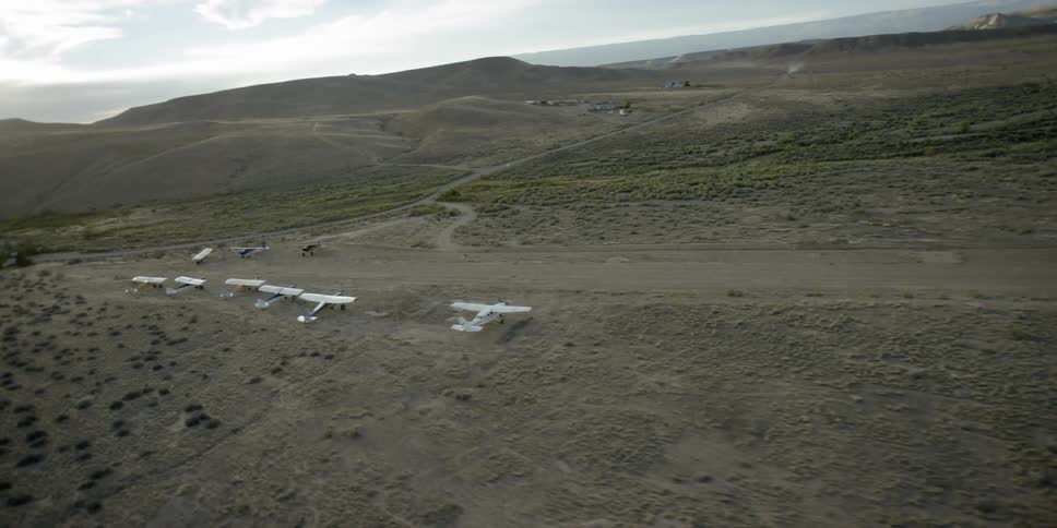 Aerial view of planes parked on a dirt field