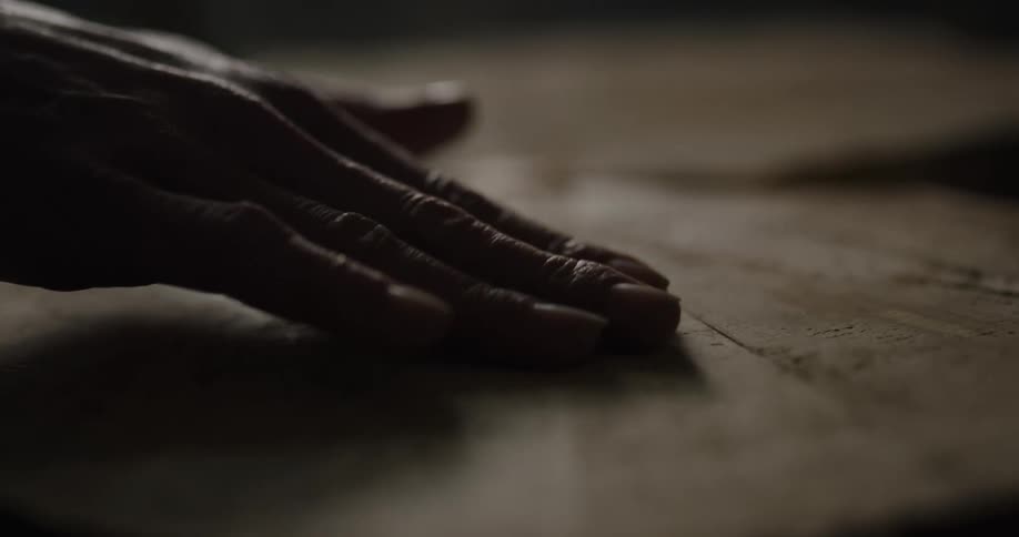 A person rubbing their hand over a piece of wood
