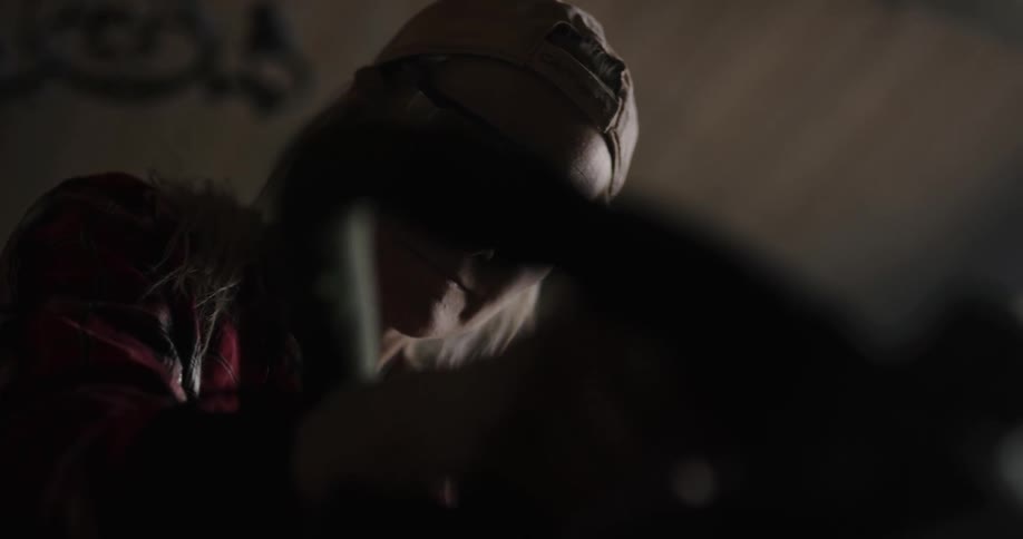 A woman in a room with a hat and goggles using an electric tool