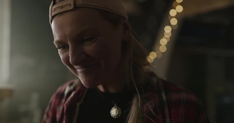 A woman in a backwards hat excited and smiling