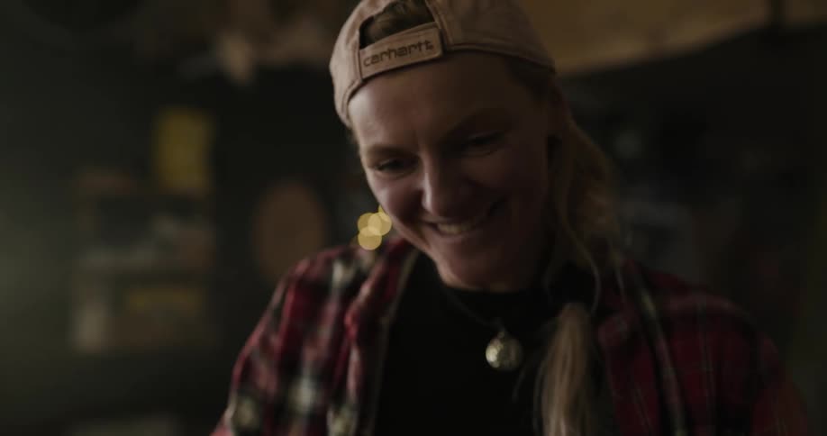 A woman in a wood shop on a laptop