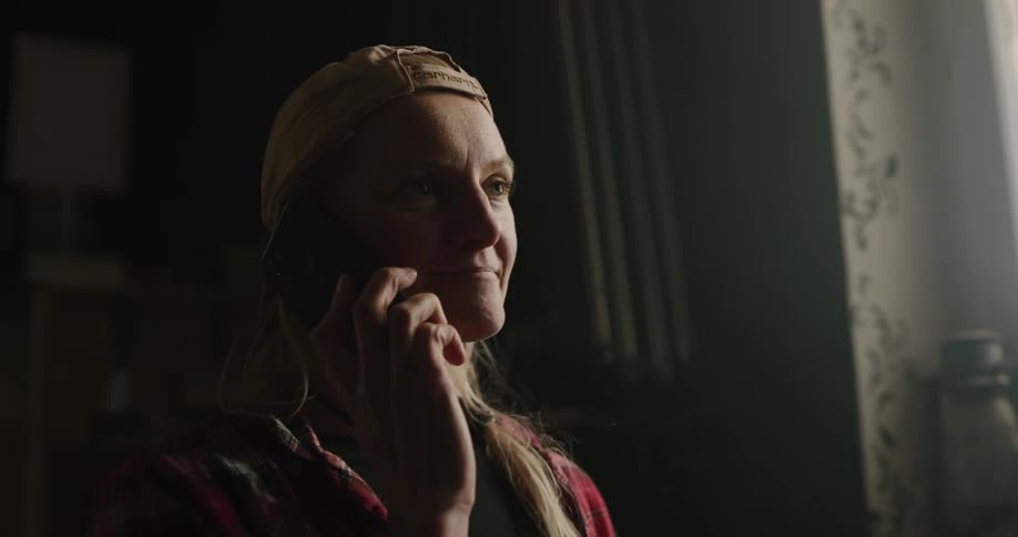A woman at home talks on her cell phone