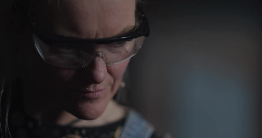 A woman is standing in a room and wearing goggles