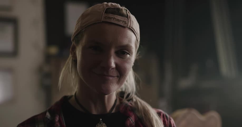 A woman in a backwards hat smiling for a portrait