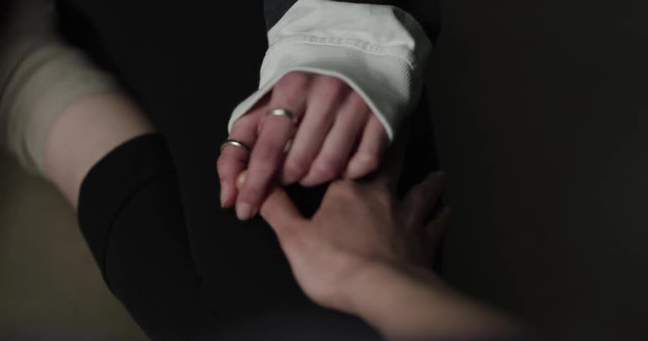 Two people are holding hands together indoors