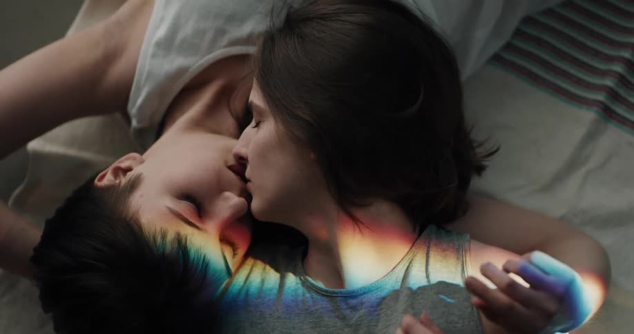 A couple kiss in the bed together