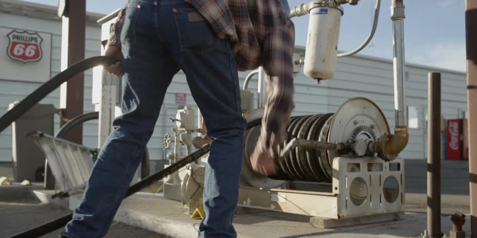 A man winds hose onto a hose reel