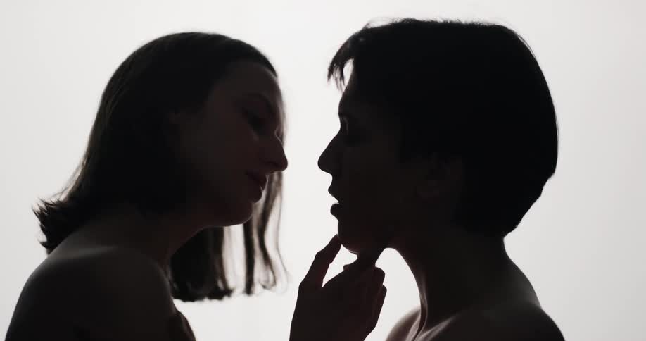A man and woman kissing and rubbing ones anothers shoulders and face