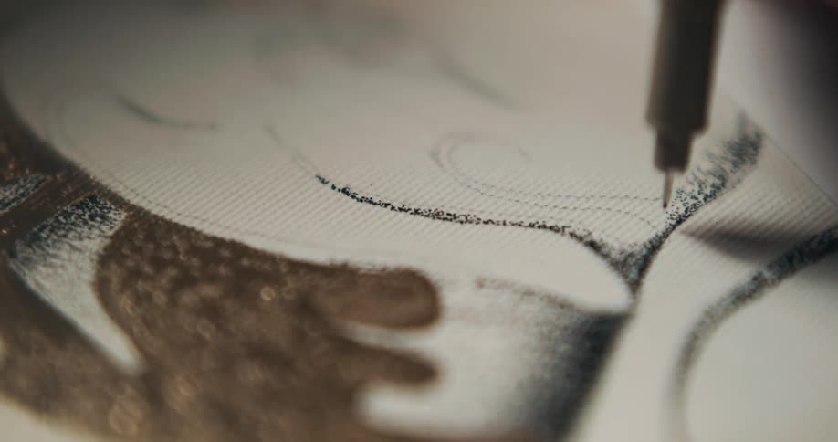 A person drawing on a canvas with pen and pencil
