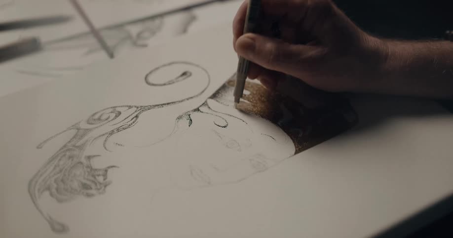 A person in a room sketching a drawing on a canvas on a table