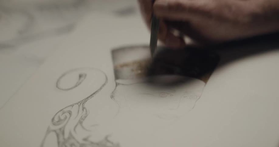 An artist drawing a person on a piece of paper